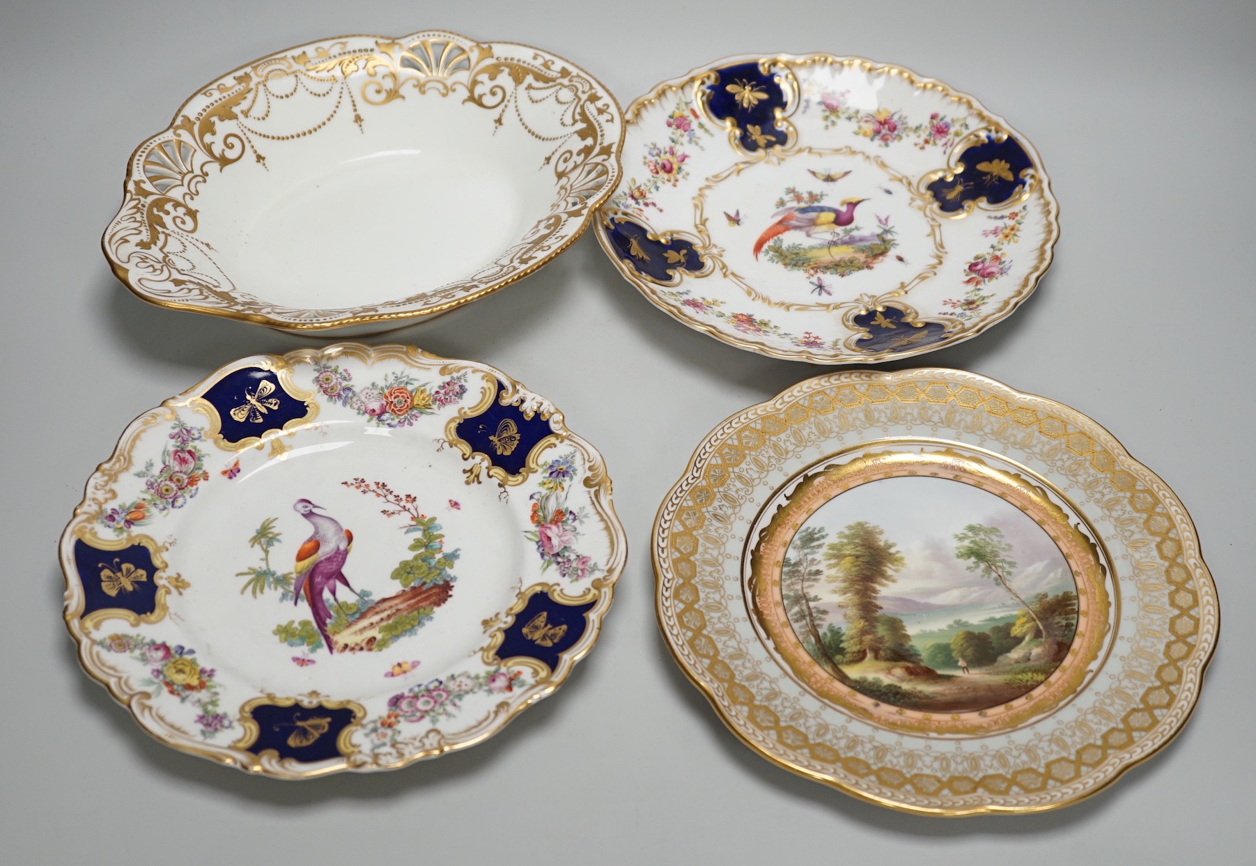 A Copeland plate decorated in Chelsea style with exotic birds on a mazarine blue ground, a similar plate probably Coalport, a Davenport plate with Windemere Lake and a Alderley pierced dish